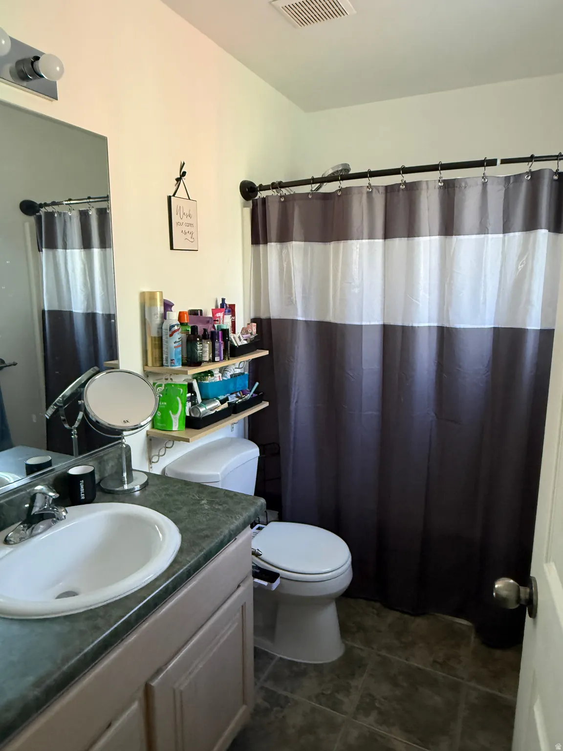 Full bathroom featuring a single vanity with an integrated sink, a built-in mirror, and a full shower with a curtain rod