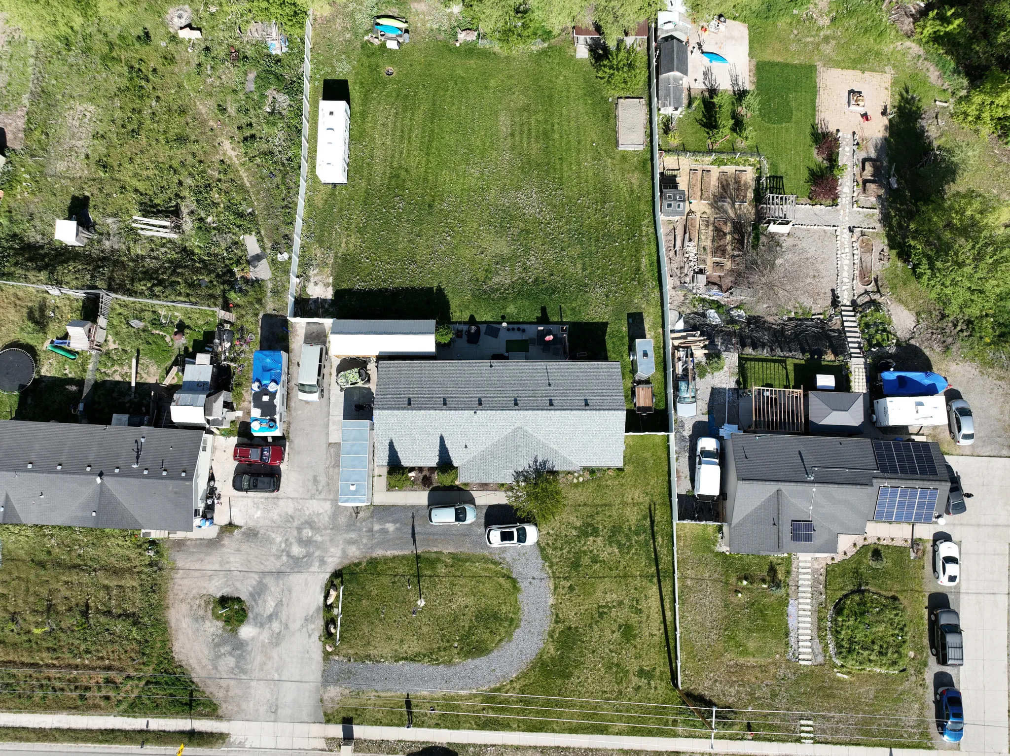 Aerial perspective showcasing multiple properties and a large, undeveloped parcel