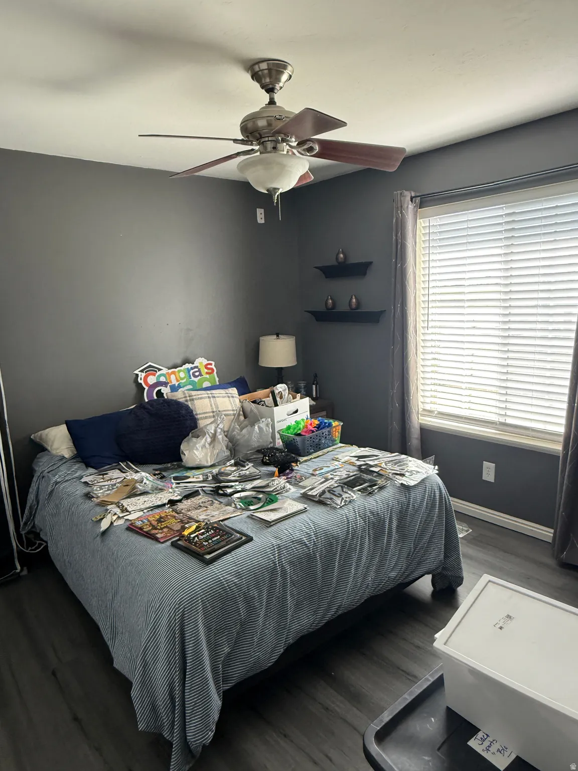 Bedroom featuring dark wood-finish flooring, a ceiling fan with integrated lighting, and neutral wall paint