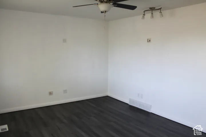 Dark wood-finish flooring with white baseboards