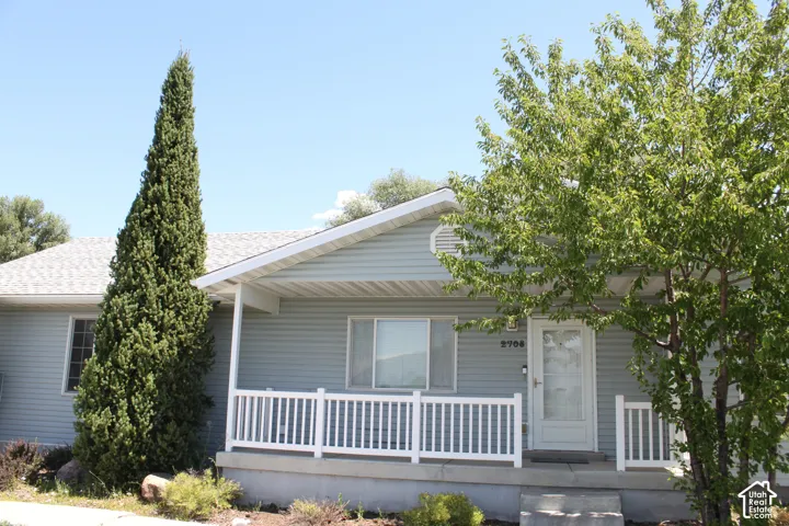 Light blue siding exterior with a covered porch featuring white railing