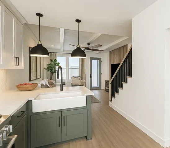 Kitchen island featuring a farmhouse sink, quartz-finish countertop, and sage green cabinetry