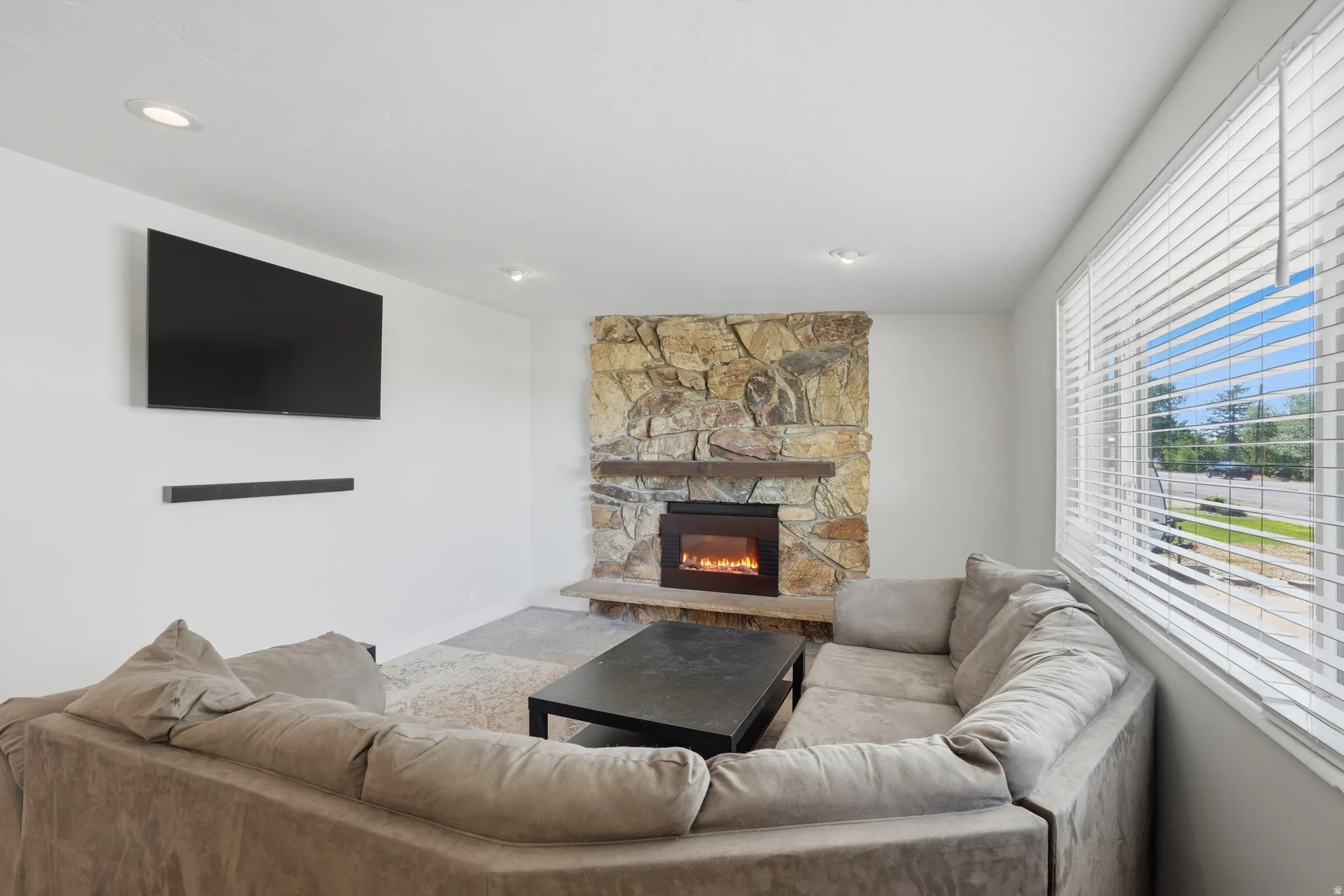 Living area featuring a stone accent wall with a built-in fireplace