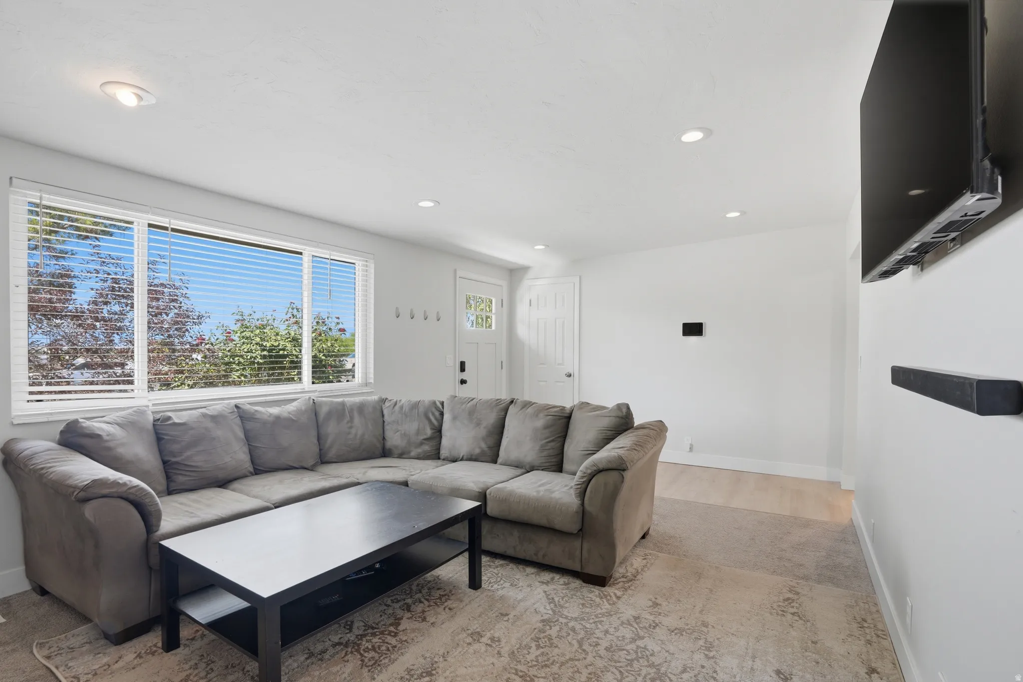 Living area featuring a large window, recessed lighting, and light wood-finish flooring