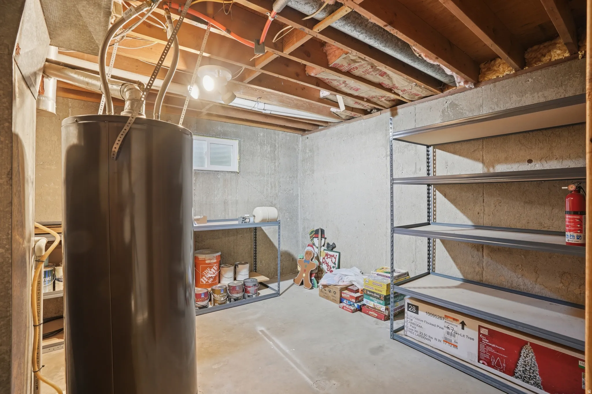 Unfinished basement featuring exposed joists, concrete walls, and a water heater