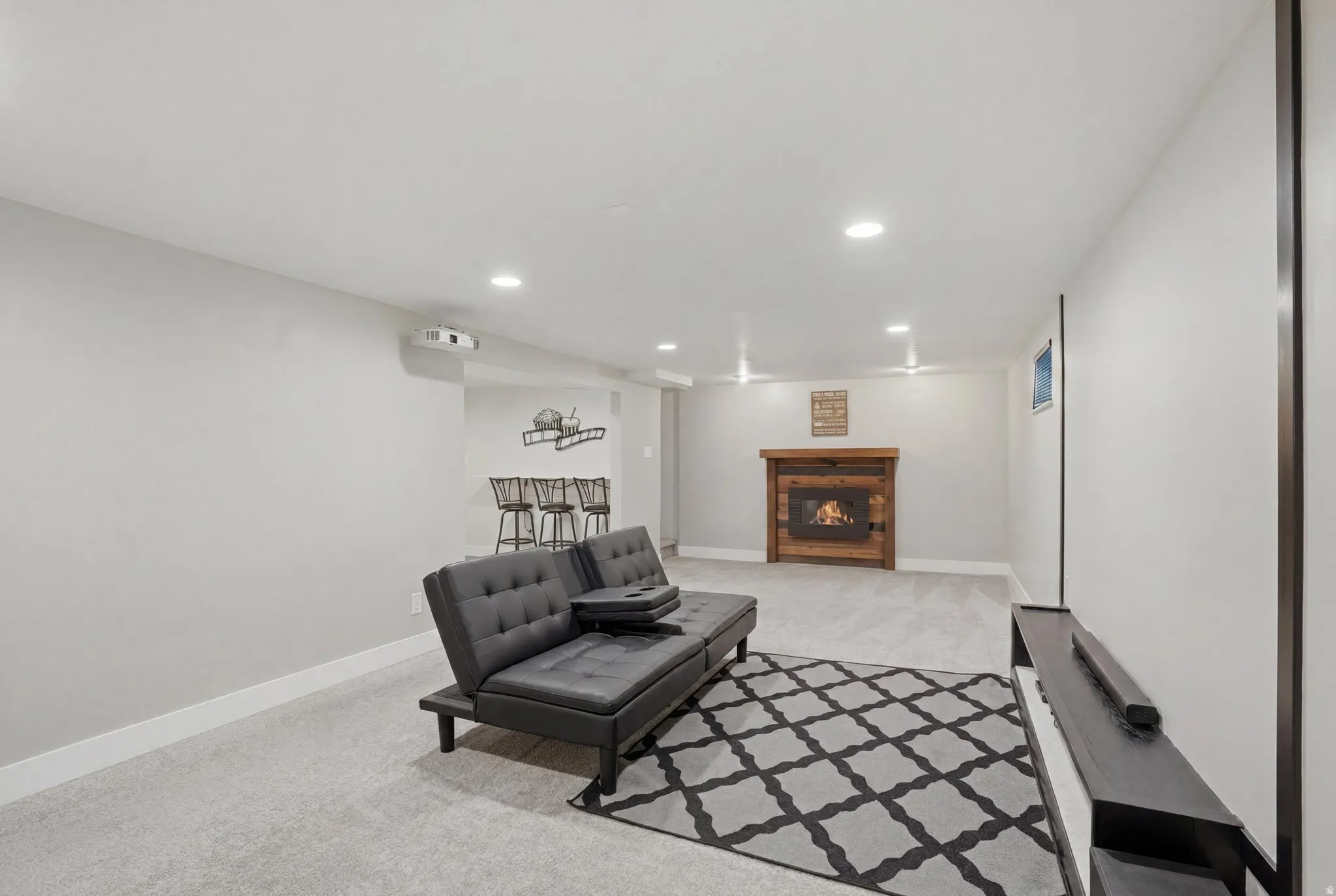 Spacious recreation room featuring recessed lighting, light-colored carpeting, and a projector