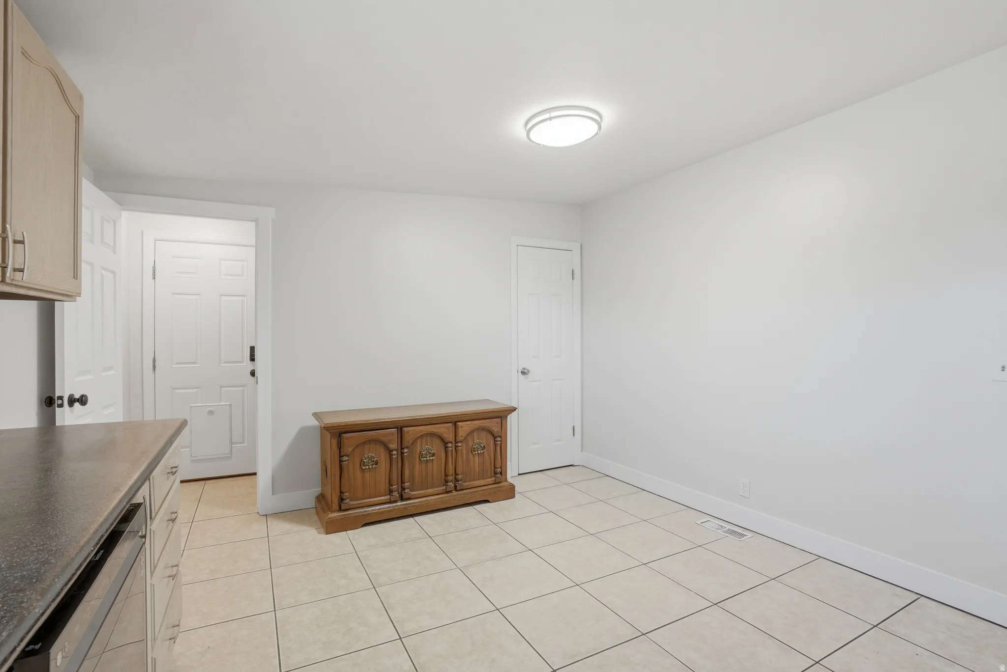 Open-concept area featuring light-toned tile flooring, recessed lighting, white walls, and white trim