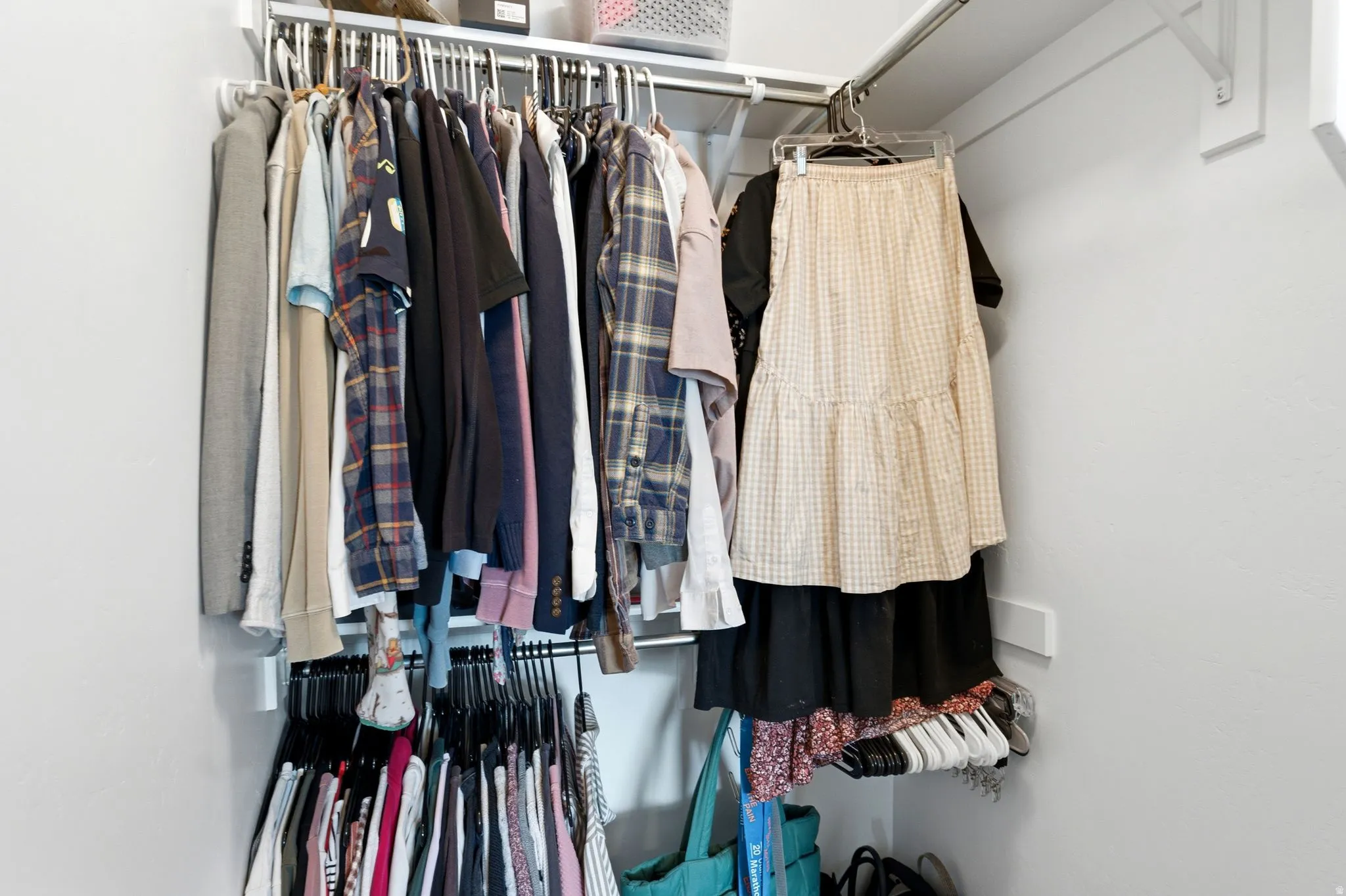 Integrated closet system featuring multiple hanging rods and a corner configuration