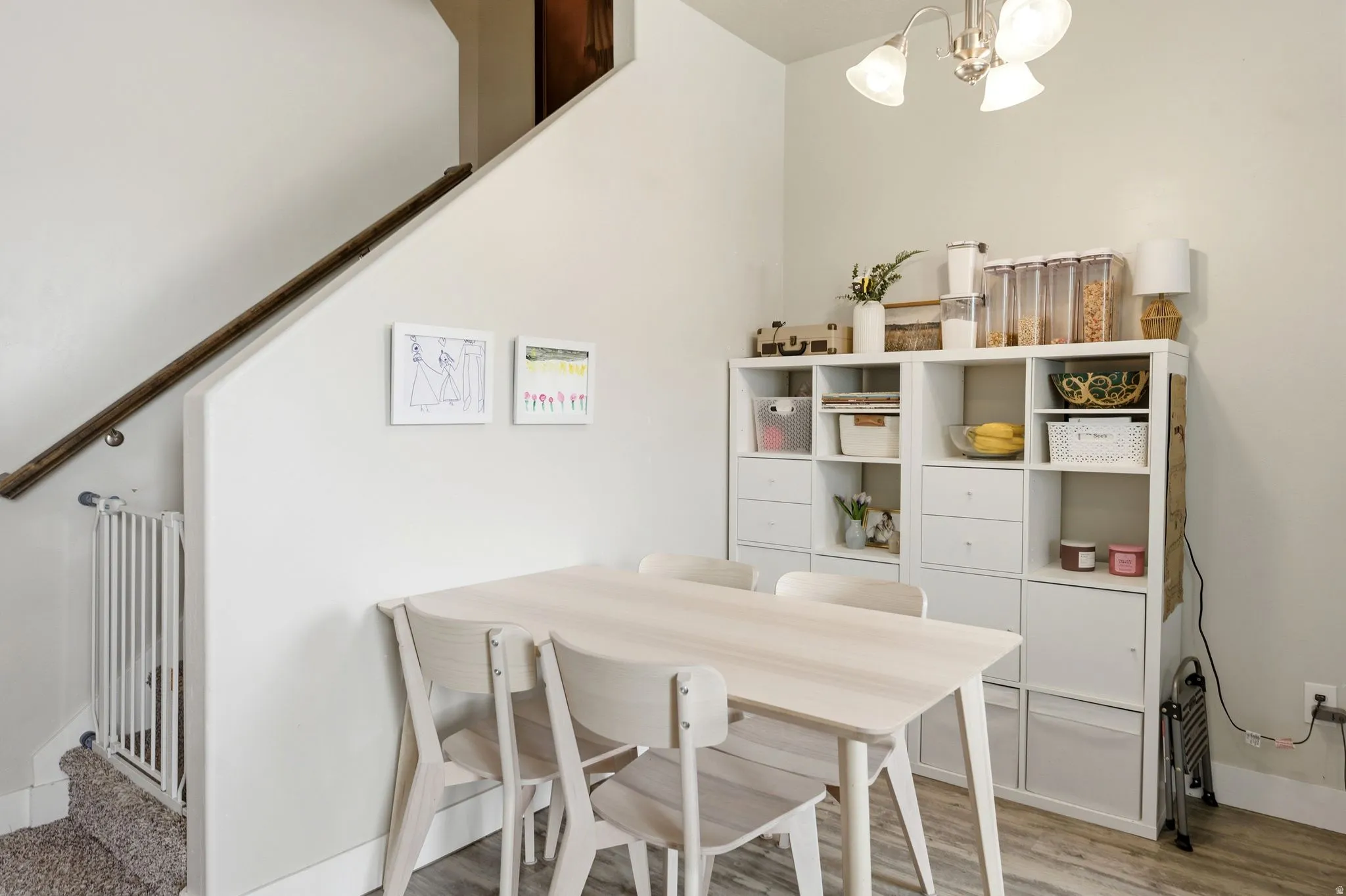 Dining area featuring wood-finish flooring and a white built-in storage unit with cubbies and drawers