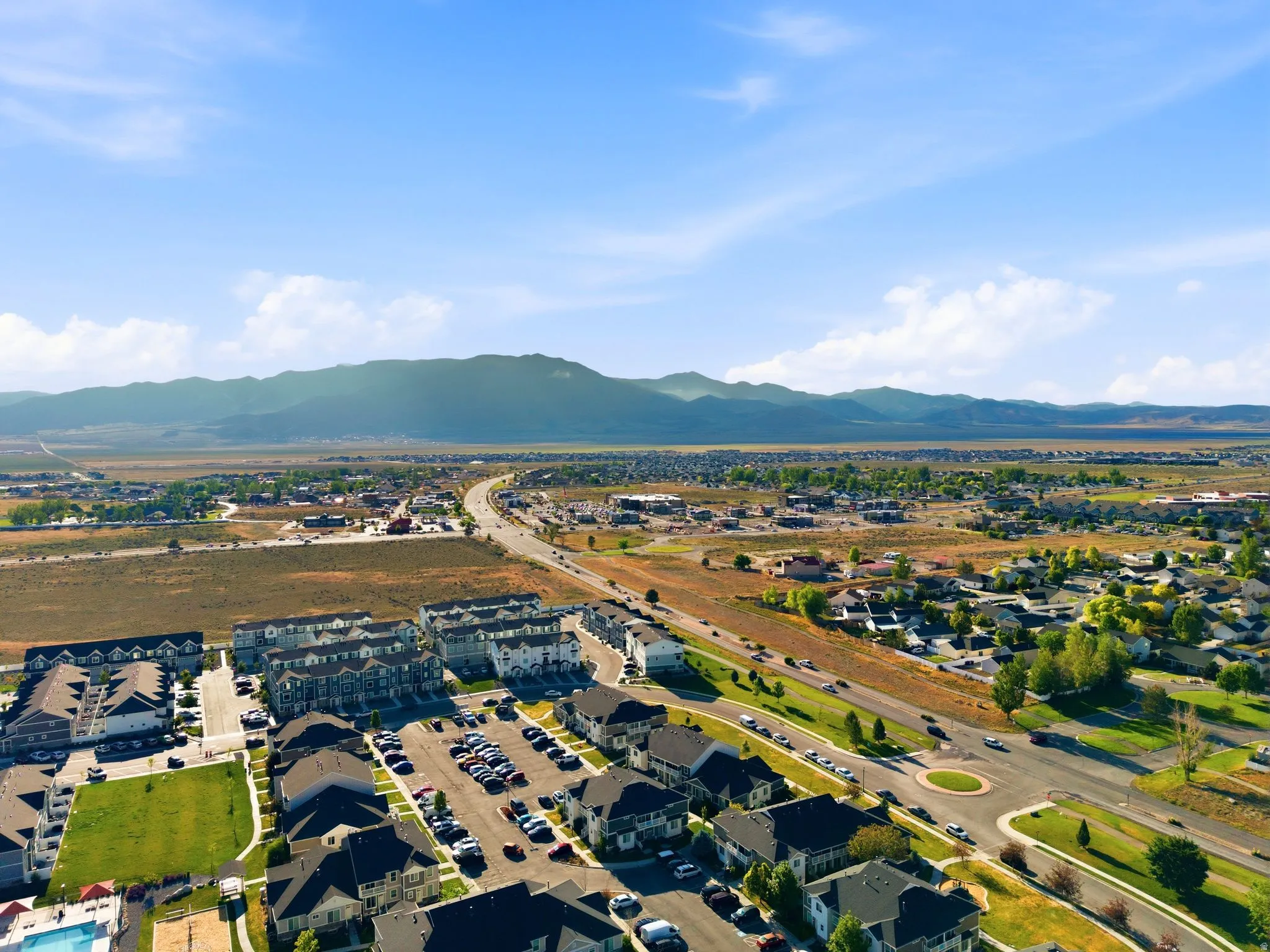 Expansive aerial perspective showcasing a residential community with distant mountain ranges
