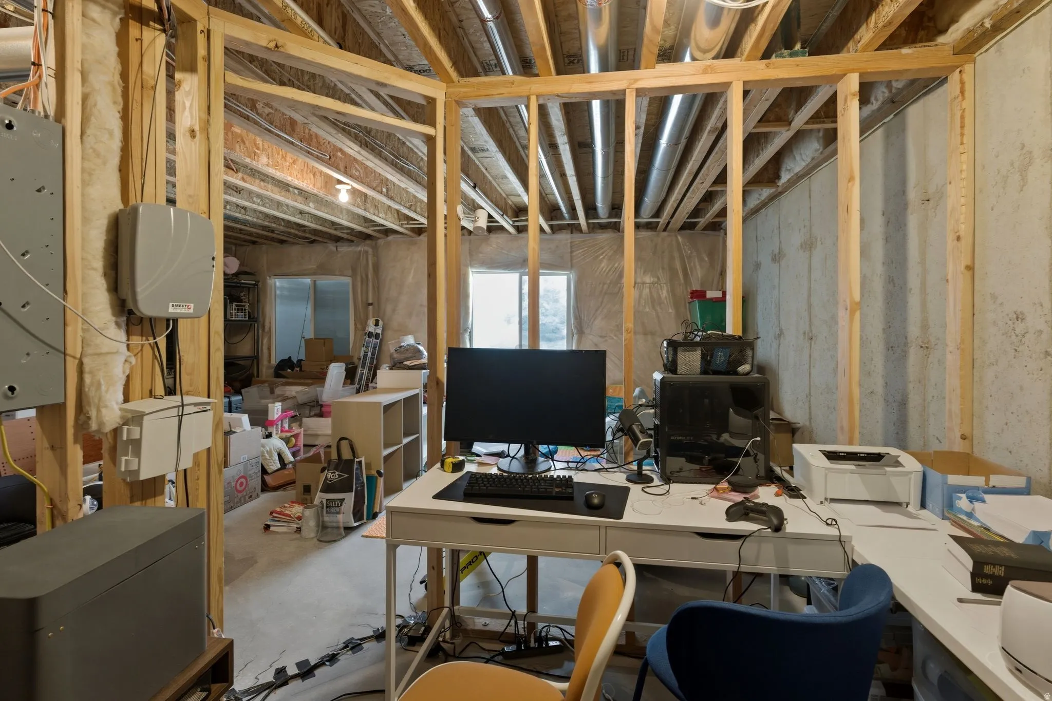Unfinished basement featuring exposed wood framing, concrete foundation walls, and visible ceiling joists