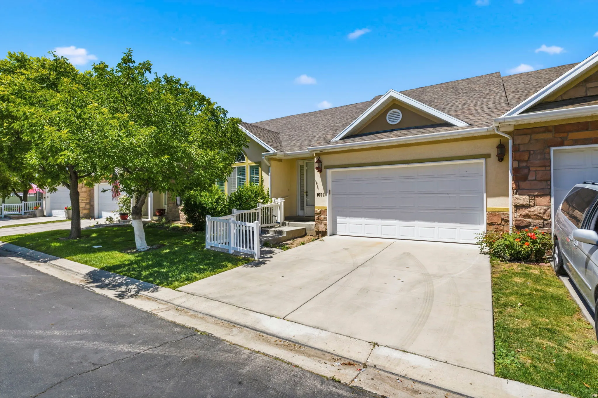 Exterior residence with a two-car garage, stone facade accents, and a concrete driveway