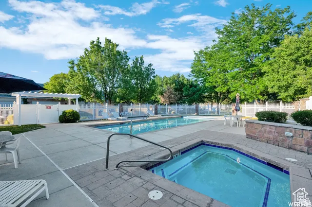 Outdoor swimming pool with an integrated hot tub featuring blue tile accents