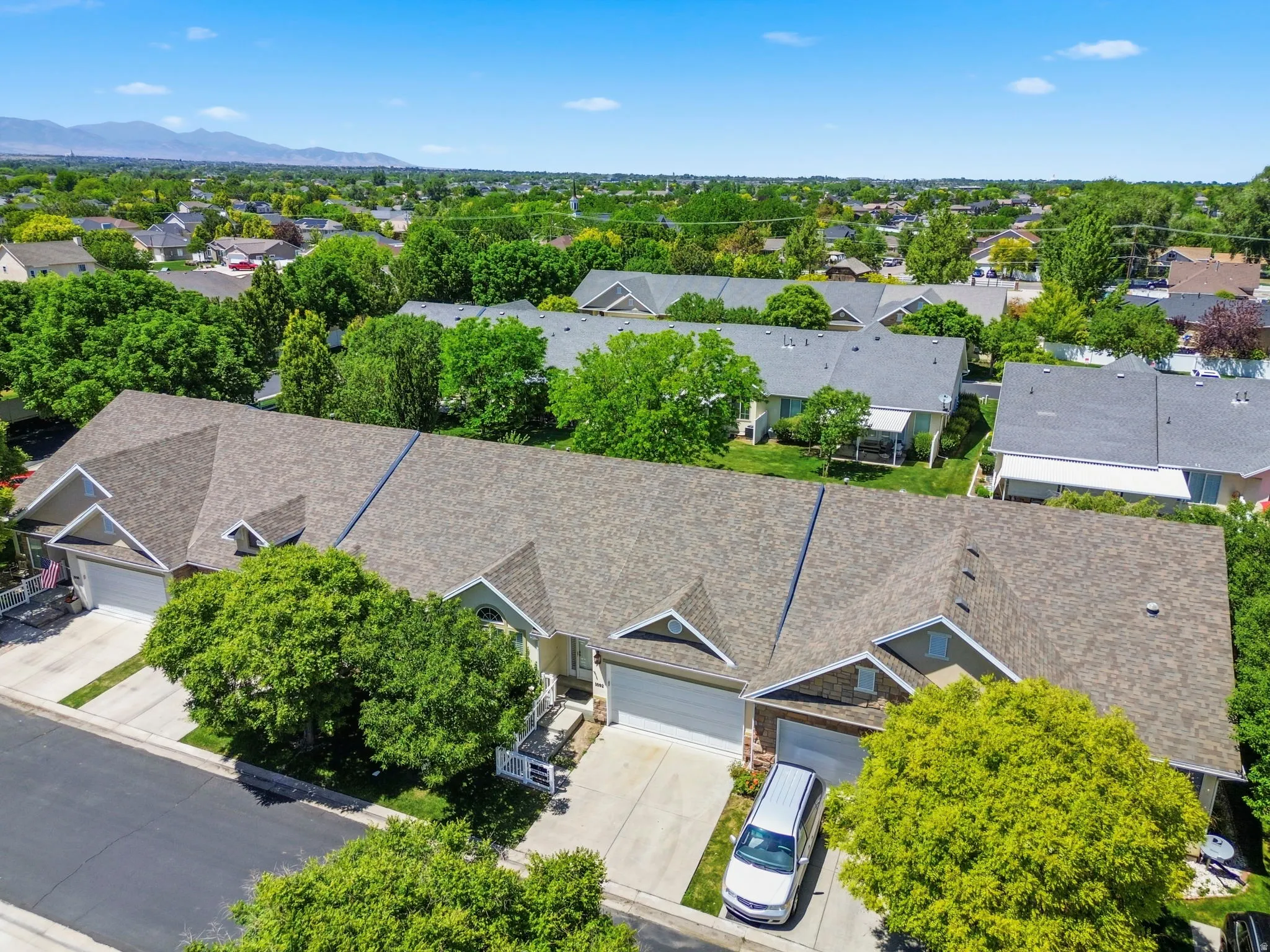 Residential property featuring a shingled roof, attached garages, and a paved driveway