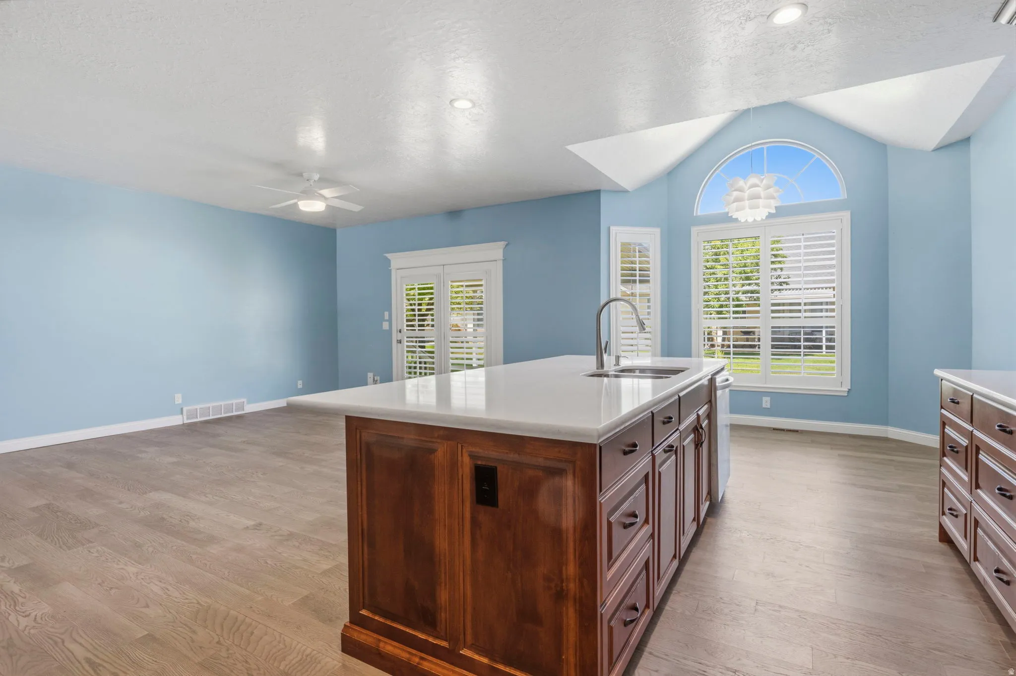 Kitchen island with an undermount sink, gooseneck faucet, and quartz countertop