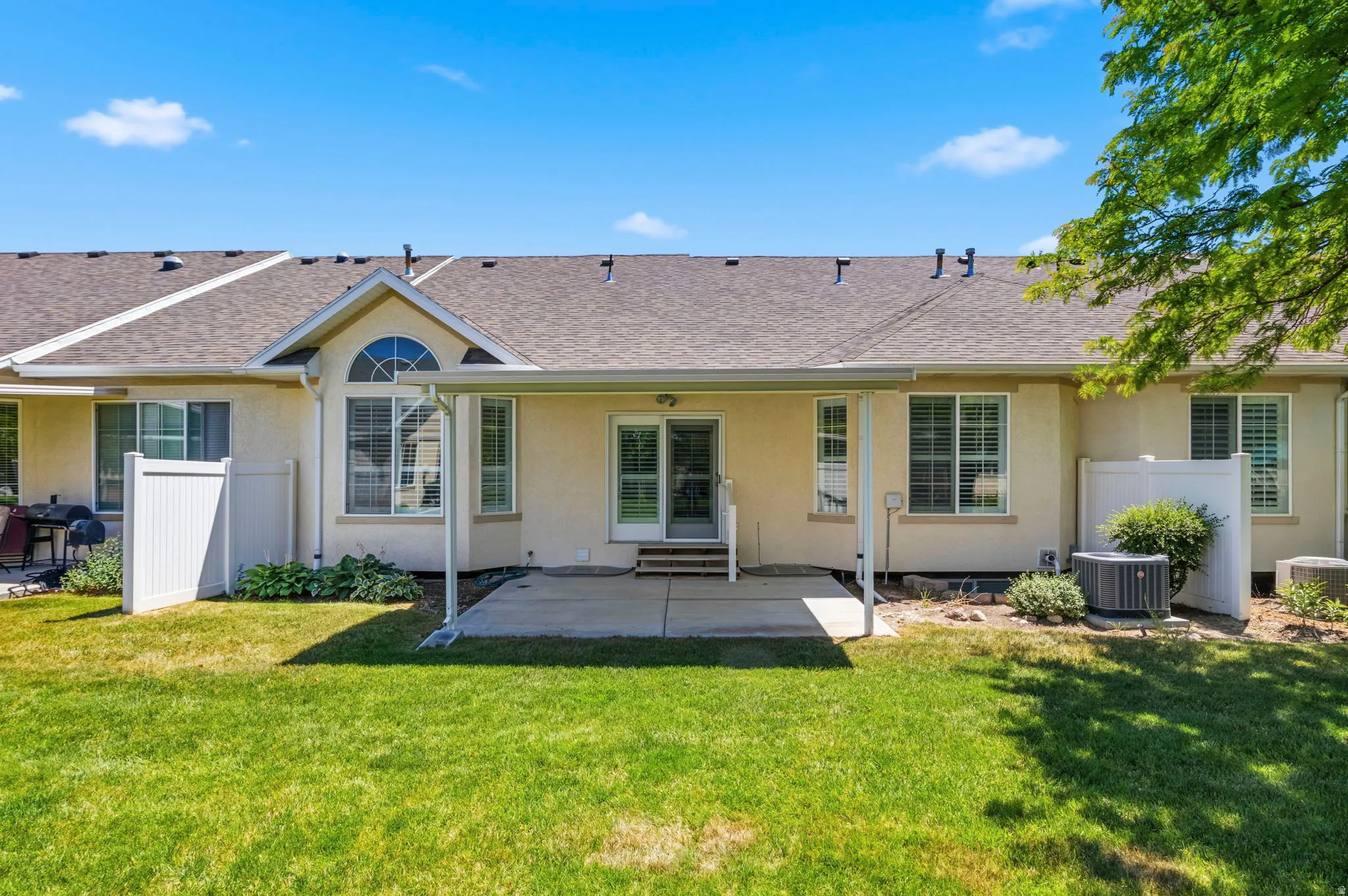 Expansive green lawn with a concrete covered patio