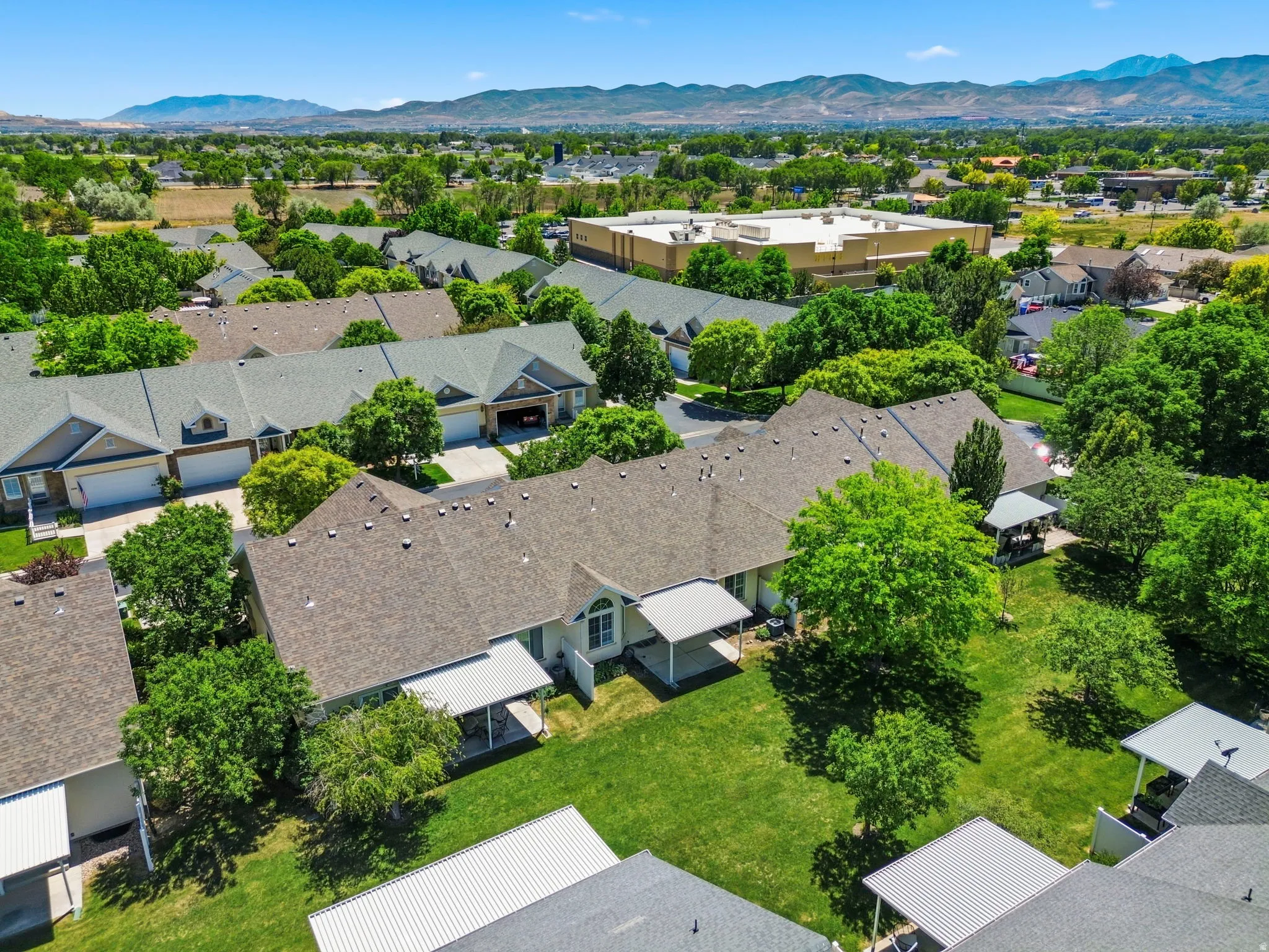 Aerial view showcasing multiple residential units with pitched roofs and attached garages