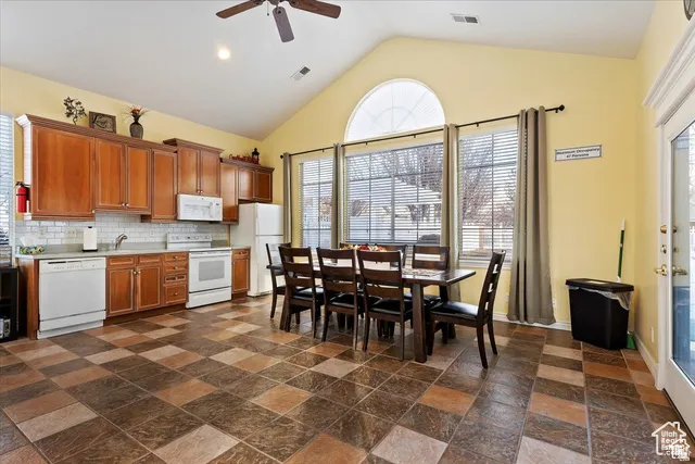 Club House Kitchen and dining area featuring vaulted ceilings, a ceiling fan, and checkered tile flooring
