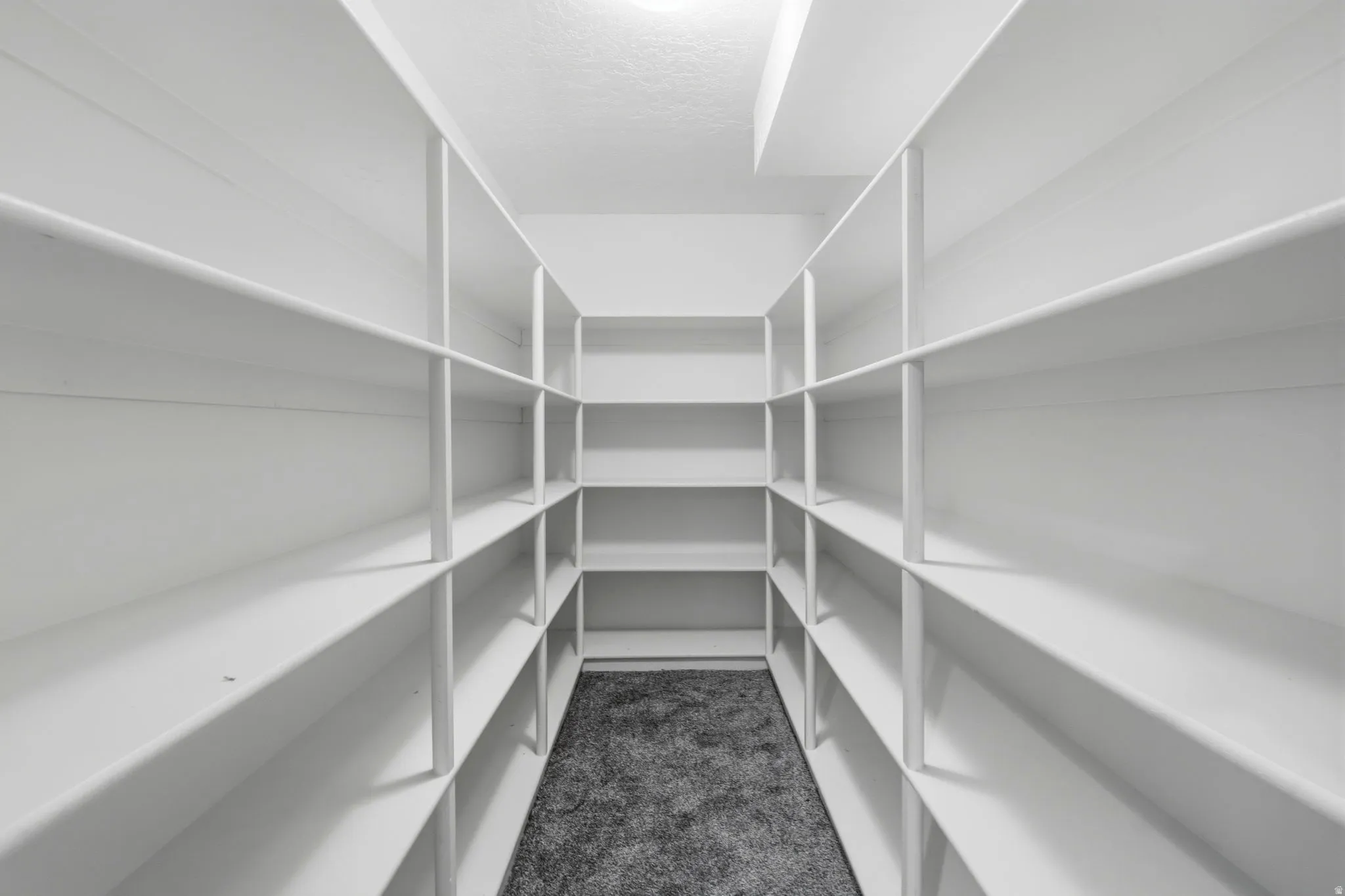 U-shaped pantry featuring extensive built-in shelving, white finishes, and recessed lighting