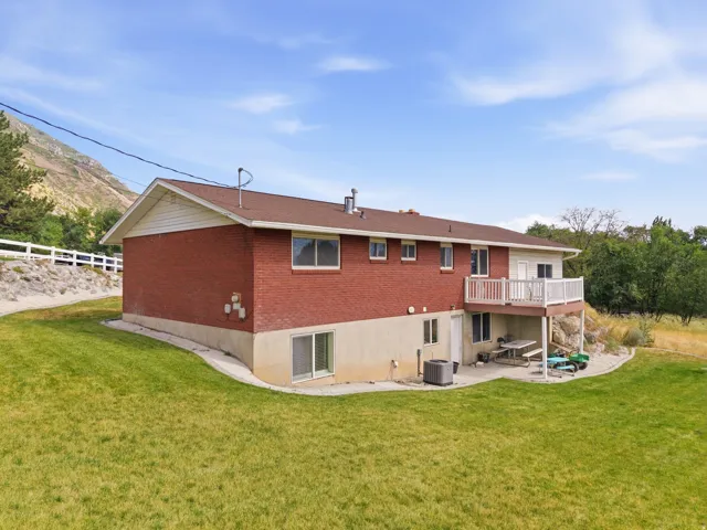 Rear exterior featuring a red brick facade, white siding, and a multi-level deck with white railings