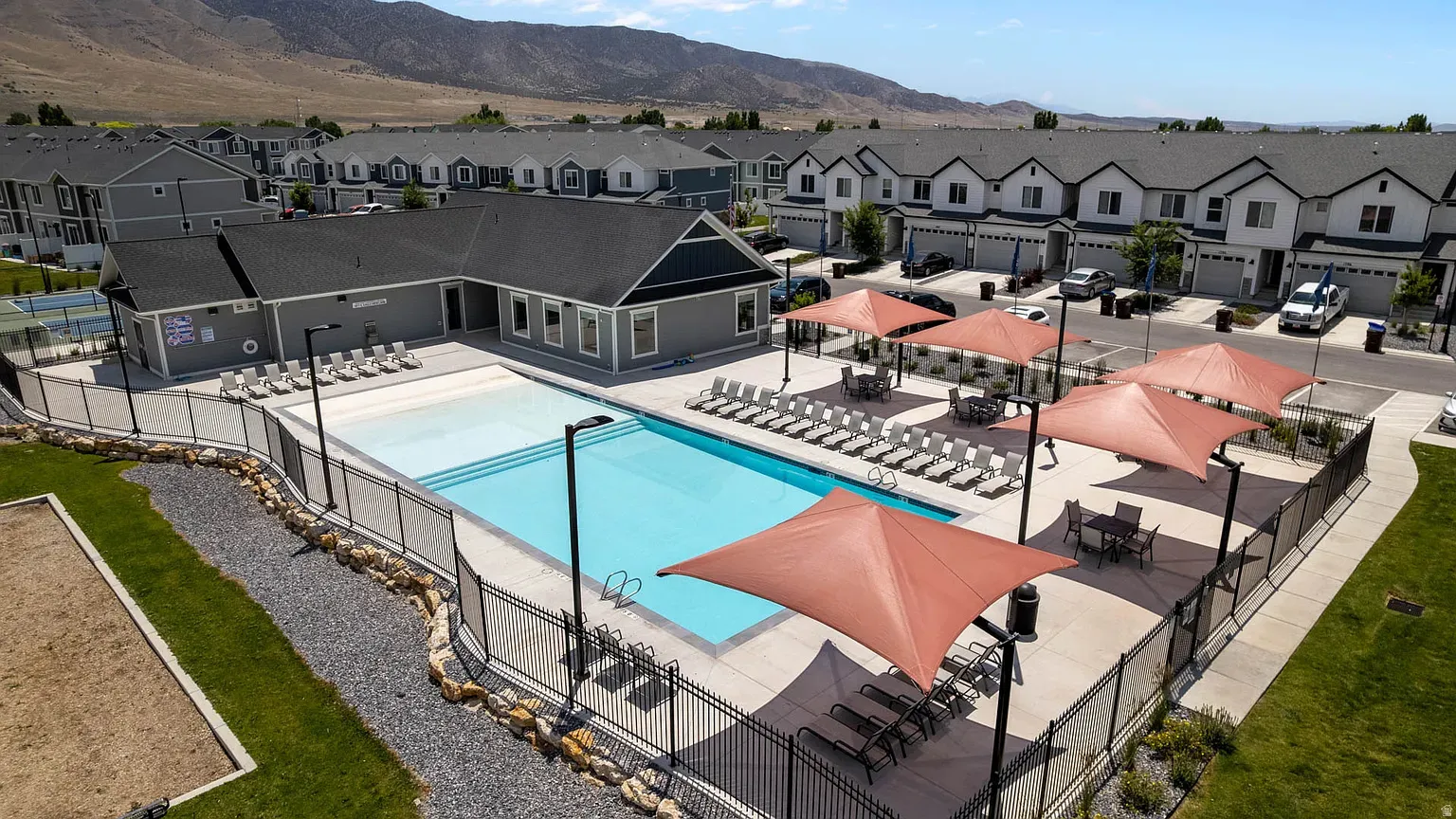 Community swimming pool area featuring a large pool, a separate covered pool section, and multiple lounge chairs