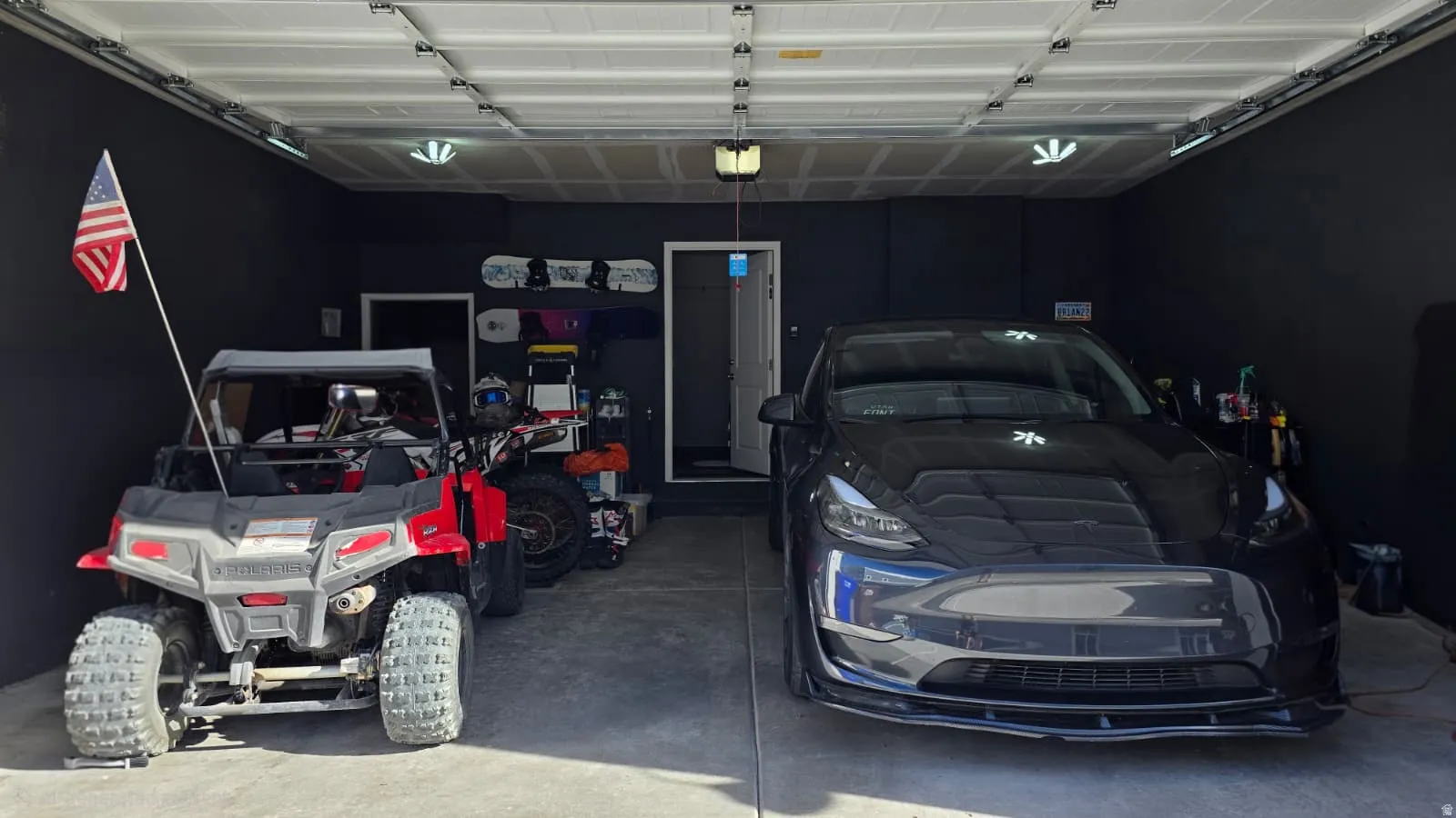 Two-car garage featuring black walls and a light concrete floor