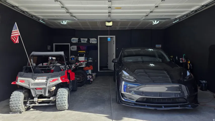 Two-car garage featuring black walls and a light concrete floor