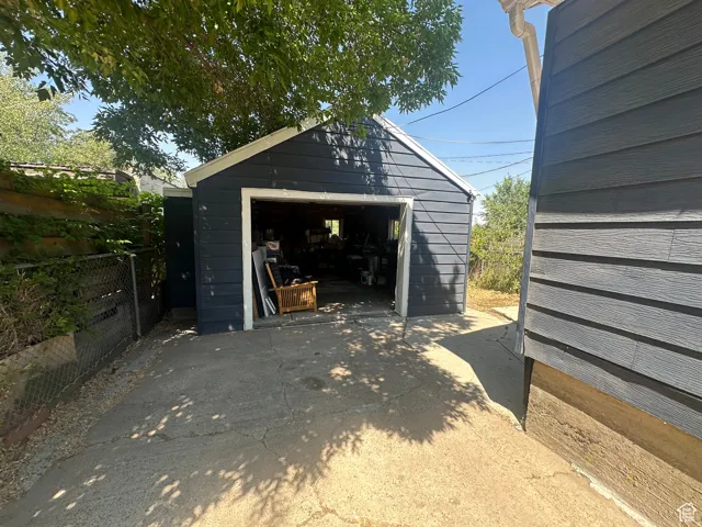 Detached garage with dark siding and white trim