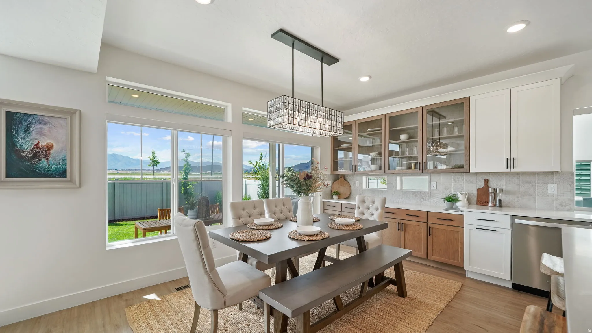 Open-concept dining area featuring wood-finish flooring and a contemporary linear chandelier