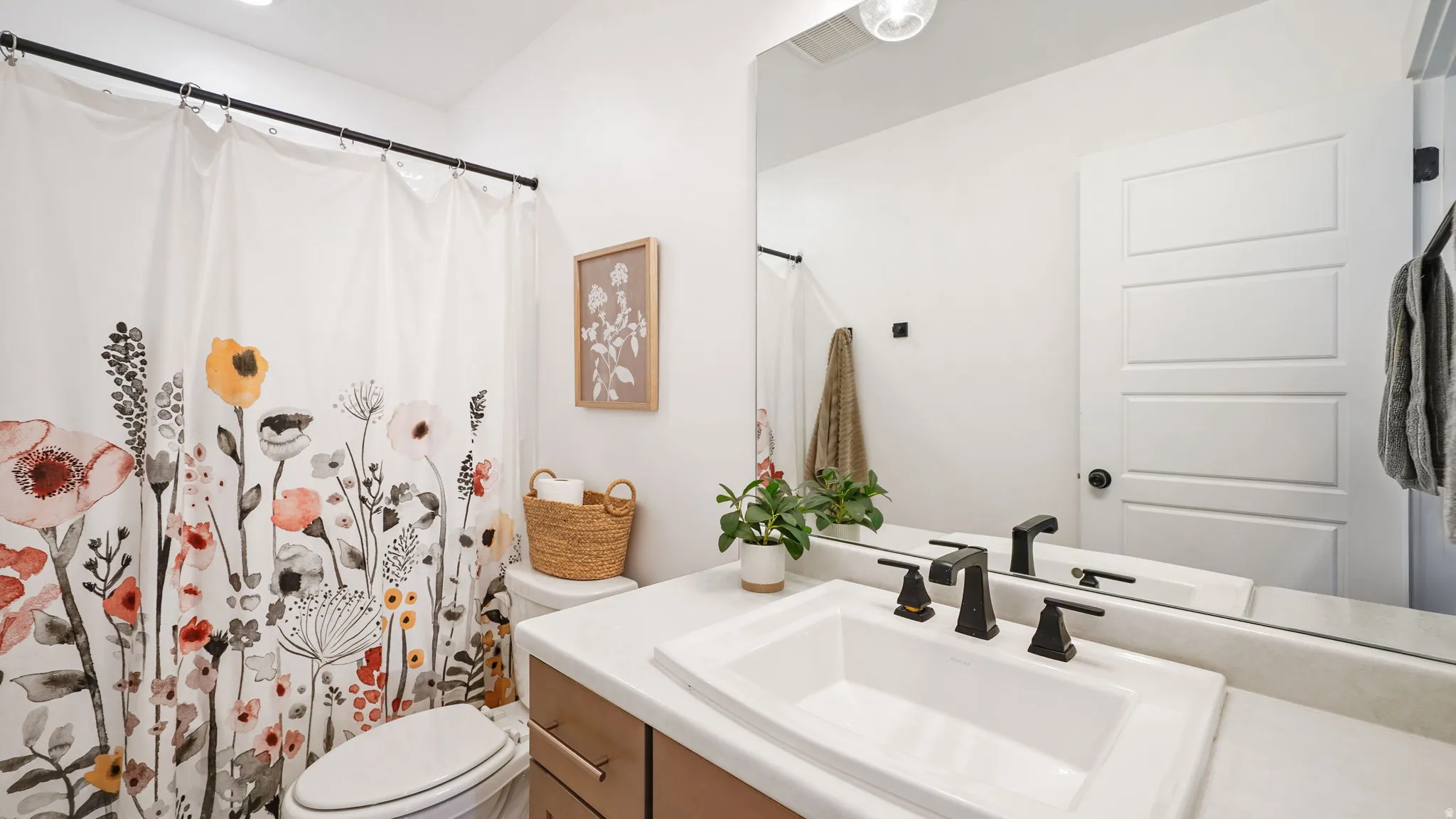 Bathroom with a single vanity, undermount sink, and matte black fixtures