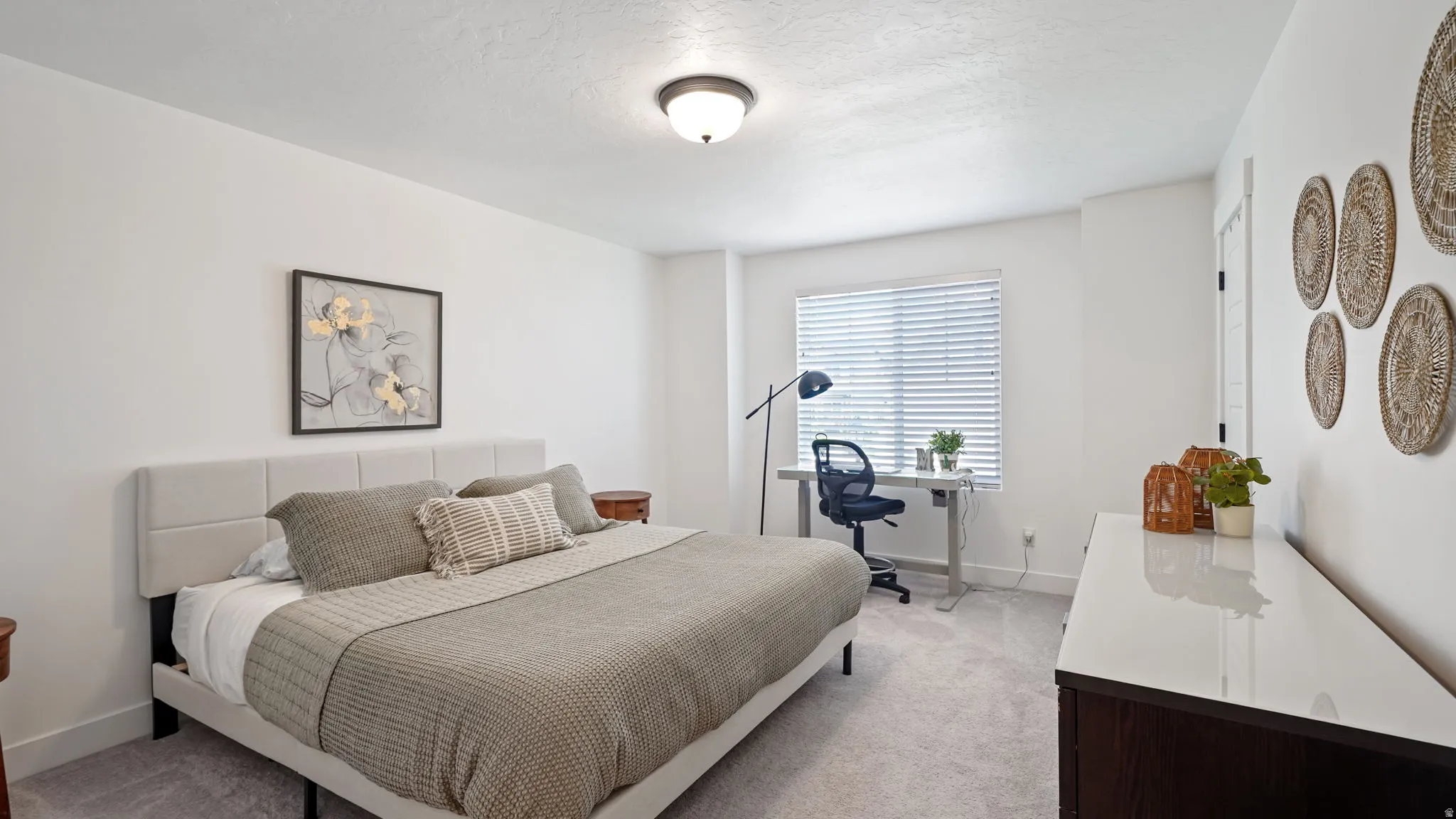 Carpeted bedroom featuring a window with blinds, a ceiling-mounted light fixture, and white walls
