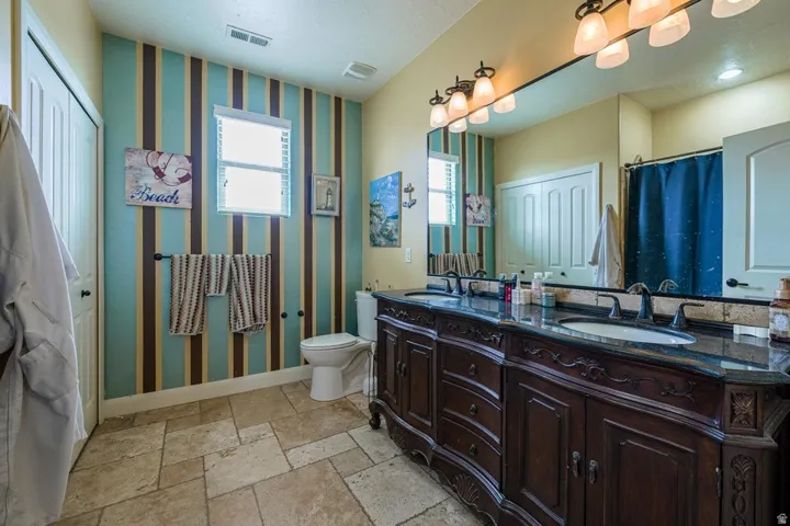 Dual vanity with dark wood cabinetry and integrated sinks, complemented by a dark countertop