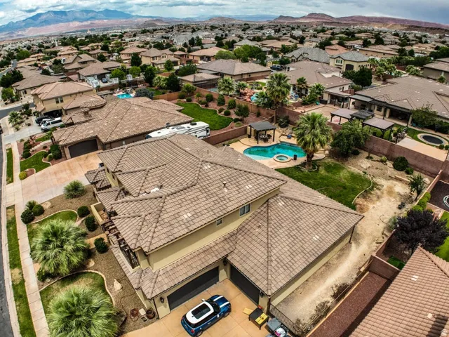 Residential property featuring a tile roof, multi-car garage, and desert-adapted landscaping