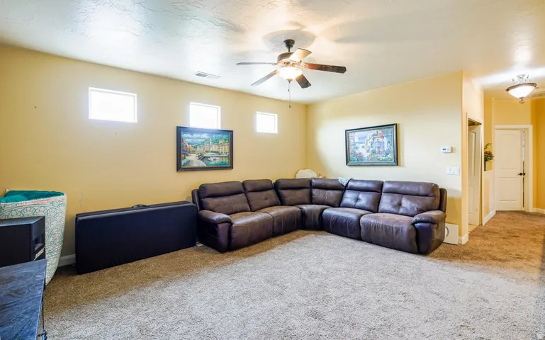 Spacious living area featuring neutral-toned carpeting and wall paint