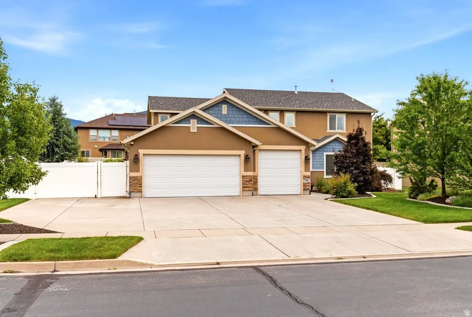 Exterior featuring a stucco facade, stone accents, and a two-car garage