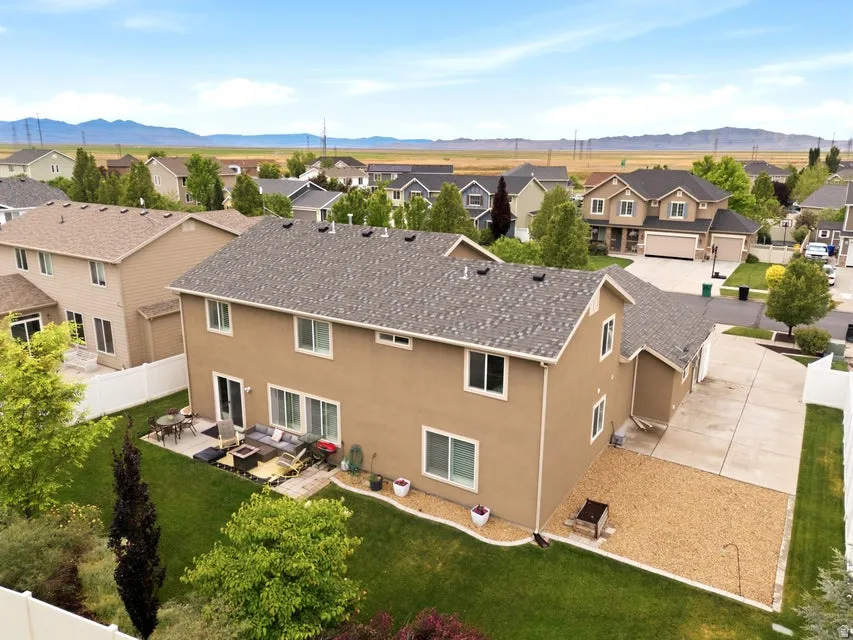 Rear exterior with a concrete patio, sliding glass doors, and a manicured lawn