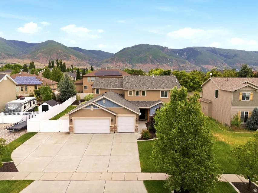 Two-story residence featuring a neutral-toned exterior with blue accent siding and a two-car garage