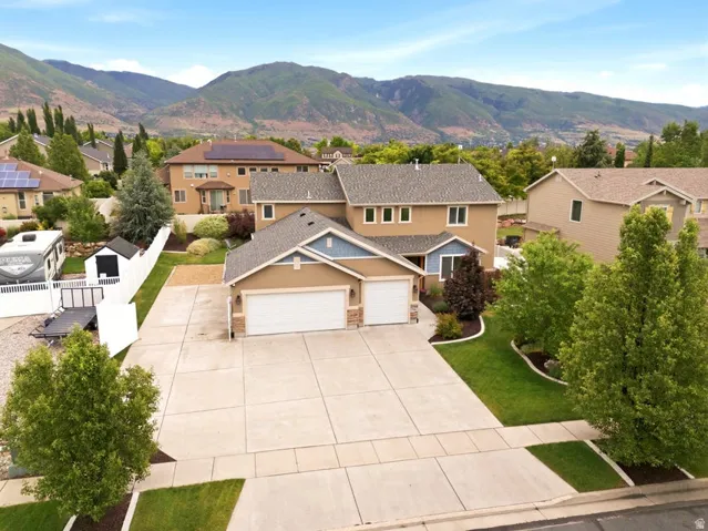 Two-story residence featuring a two-car garage, concrete driveway, and a fenced side yard