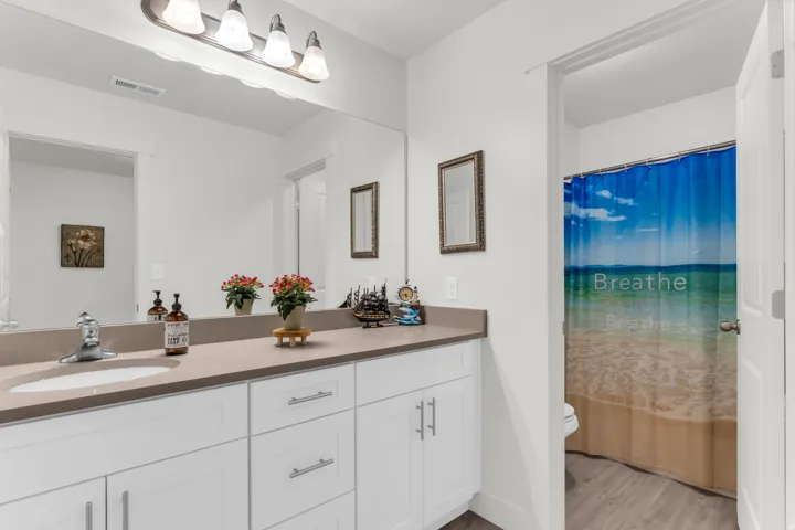 Bathroom featuring a dual-sink vanity with white cabinetry and a light-toned countertop