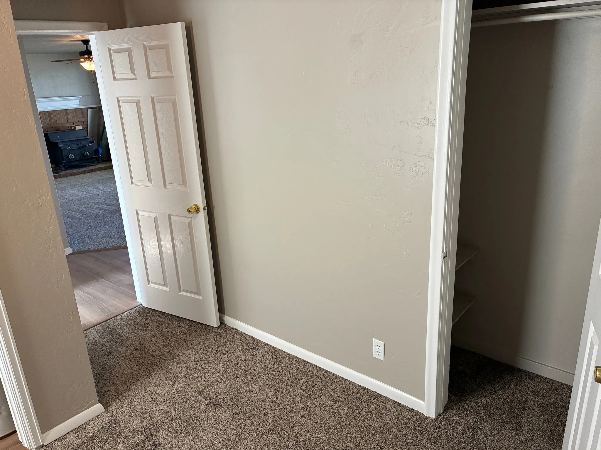 Neutral-toned wall with white trim and a contrasting brown carpet