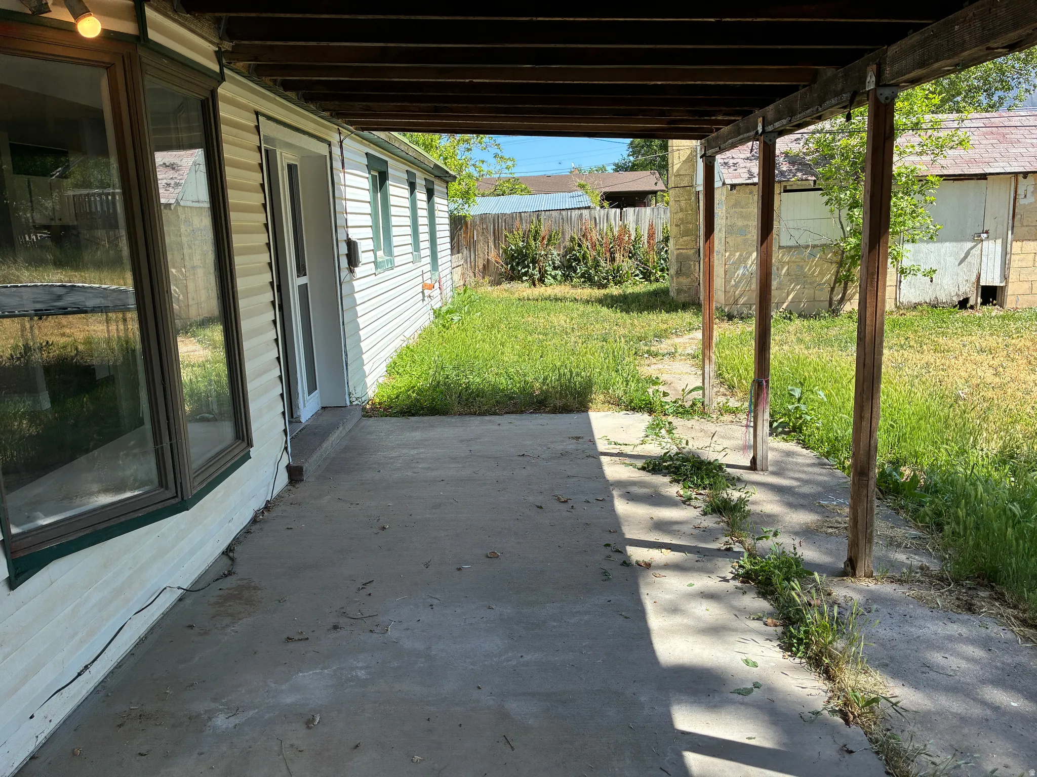 Rear concrete patio with overhead wood beam structure