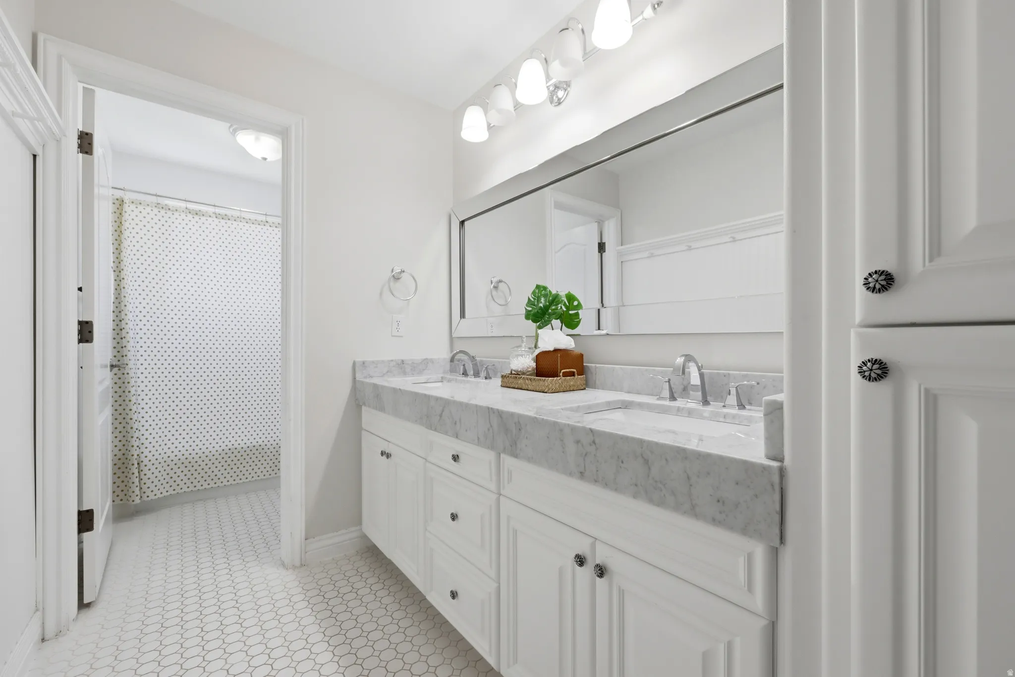 White shaker-style double vanity with a stone countertop and two undermount sinks
