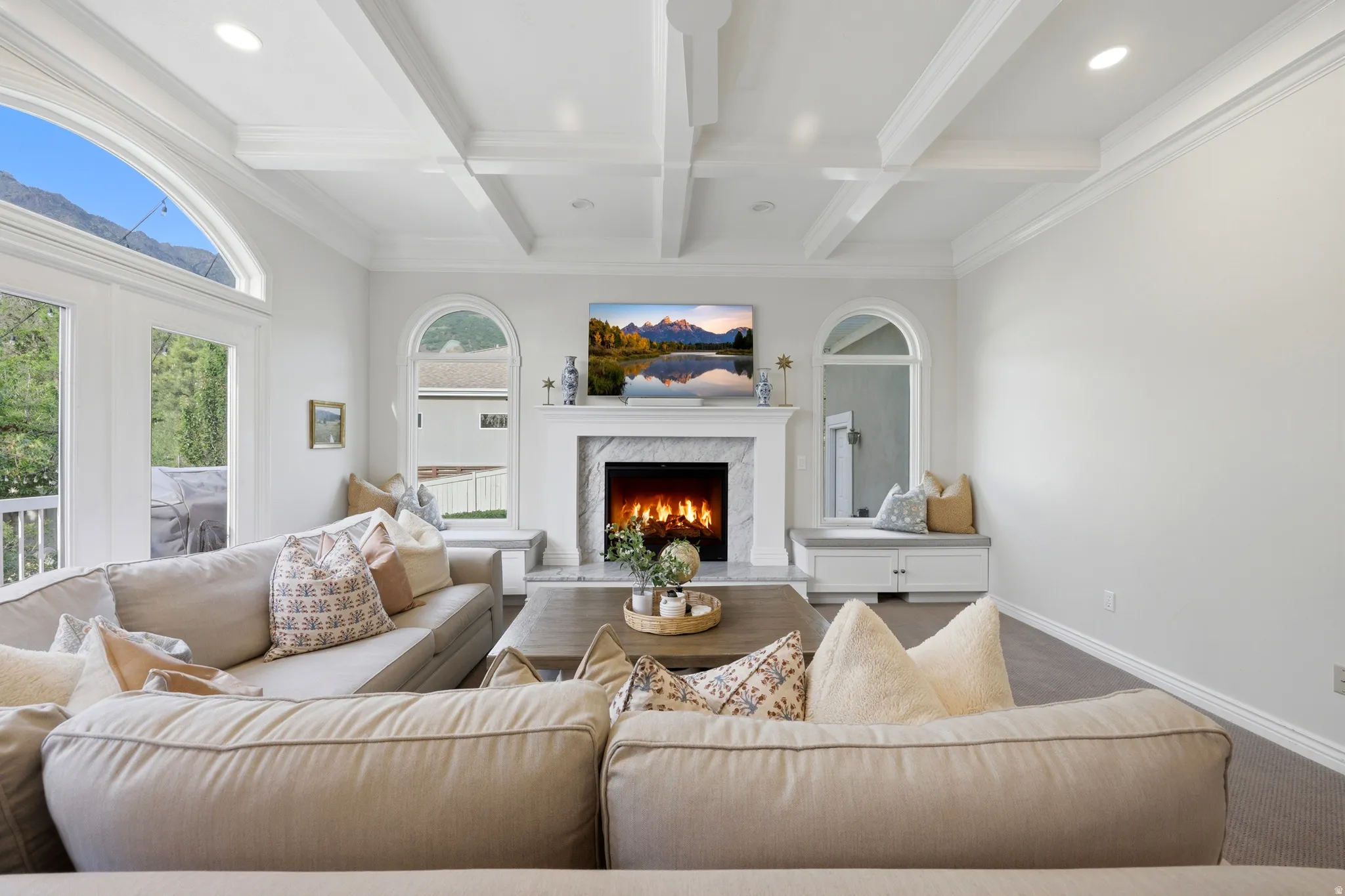 Living area featuring a coffered ceiling, recessed lighting, and a marble-surround fireplace