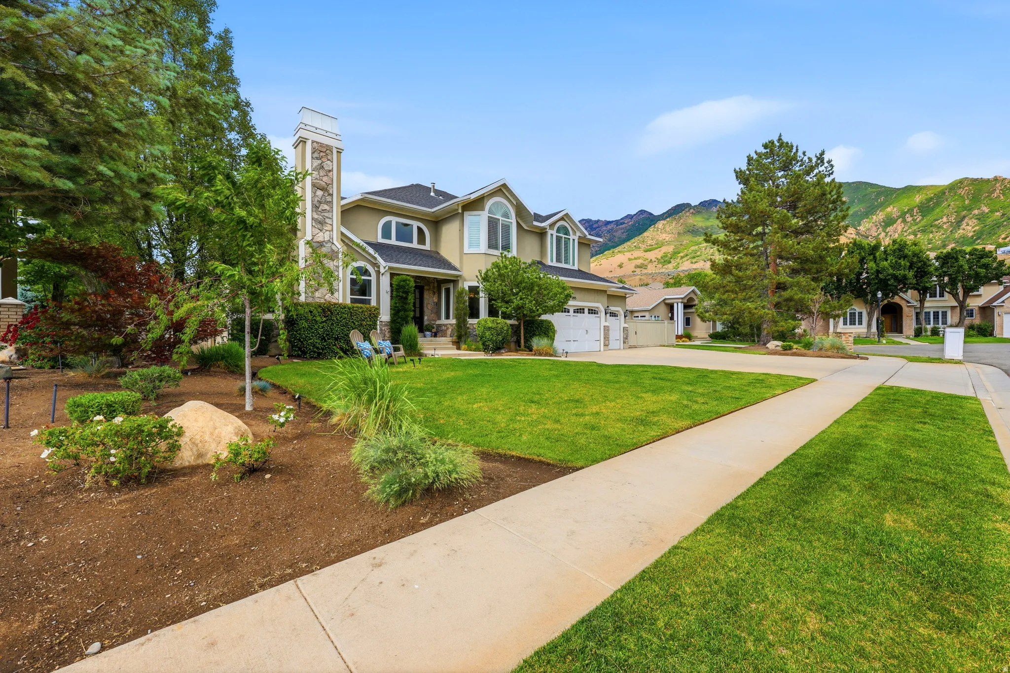 Two-story residence featuring a stone-clad chimney and arched windows