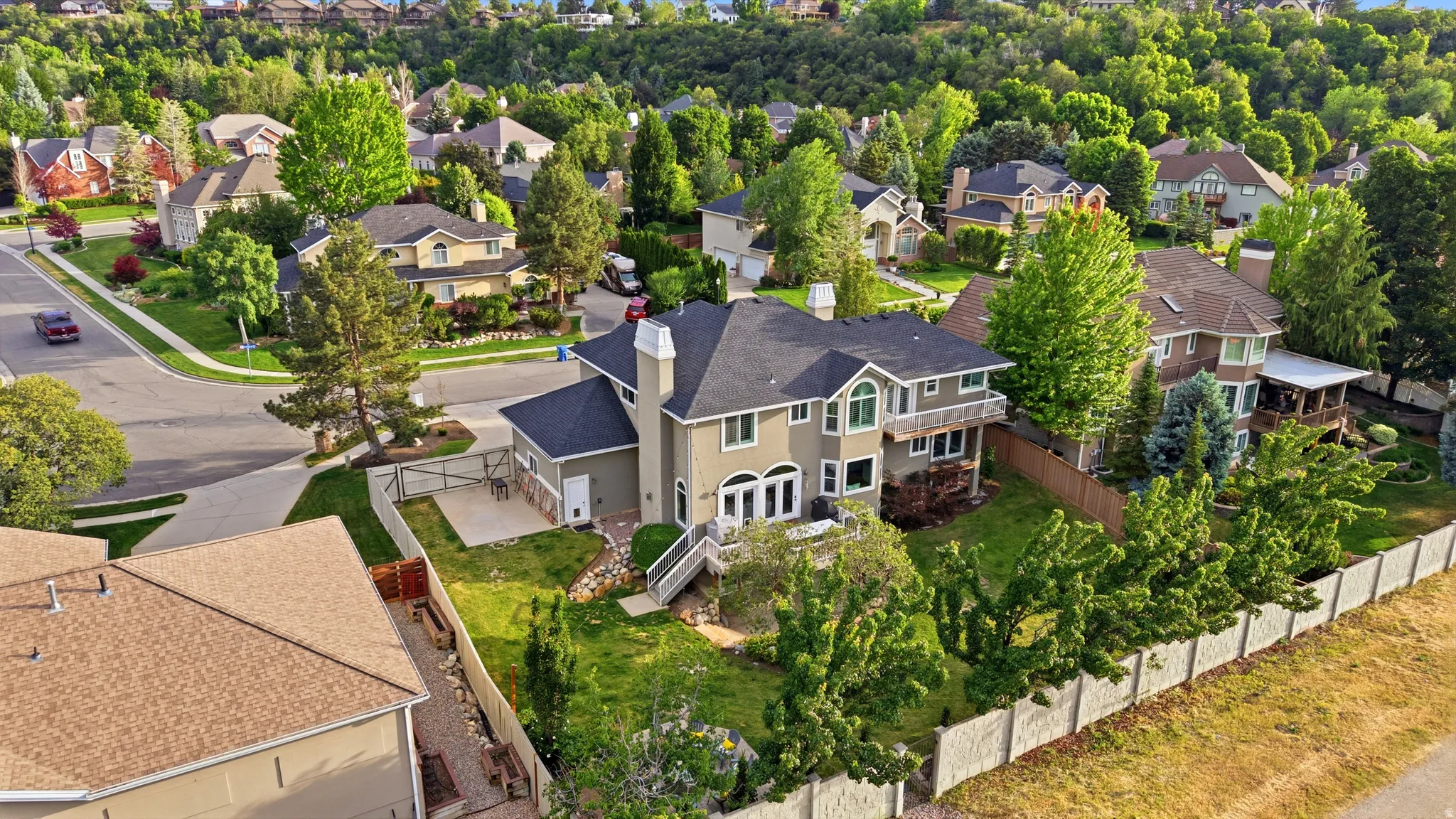 Multi-story residence featuring a neutral-toned facade, dark shingle roof, and multiple gables