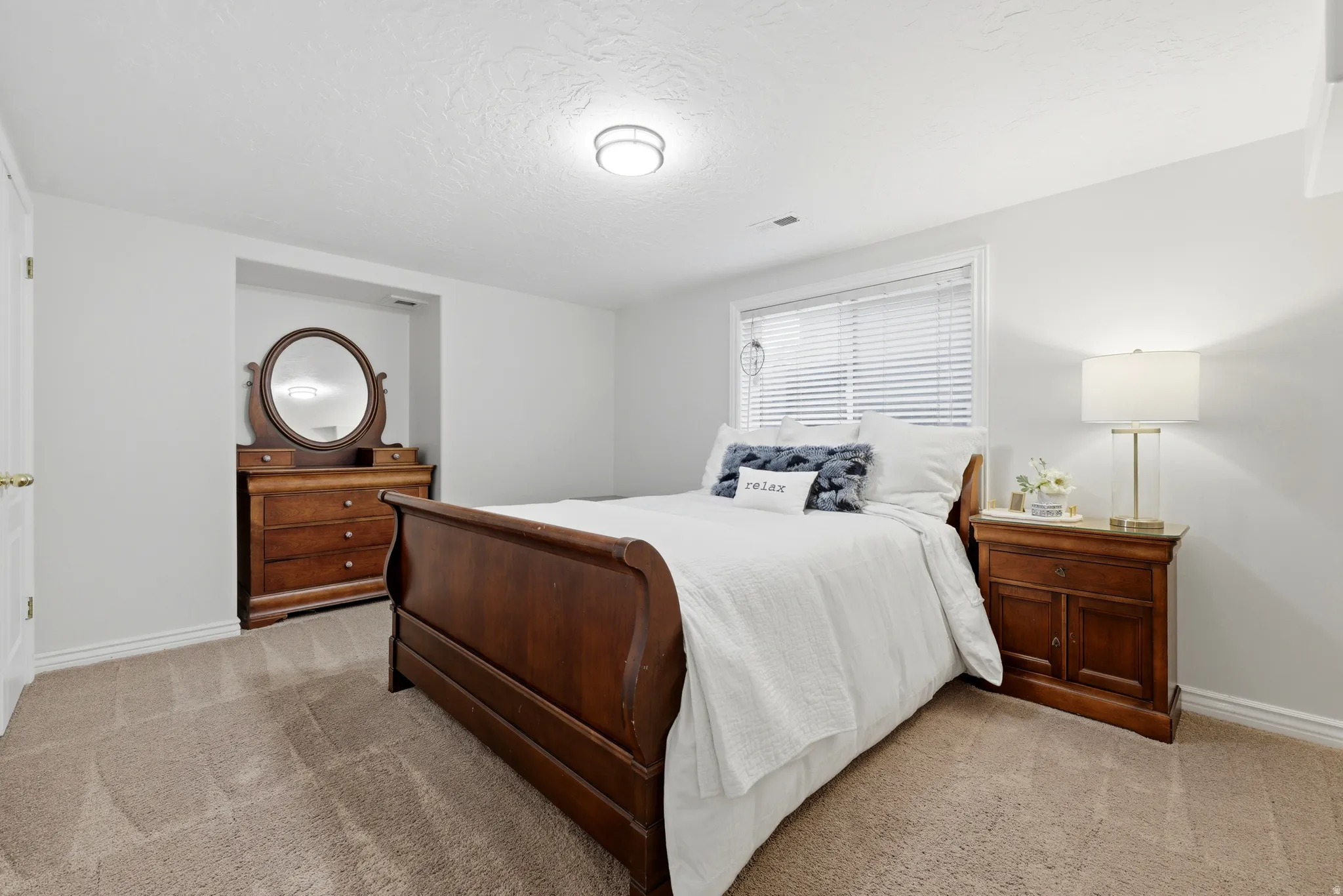 Spacious room featuring neutral carpet flooring, light-colored walls, and a window with blinds