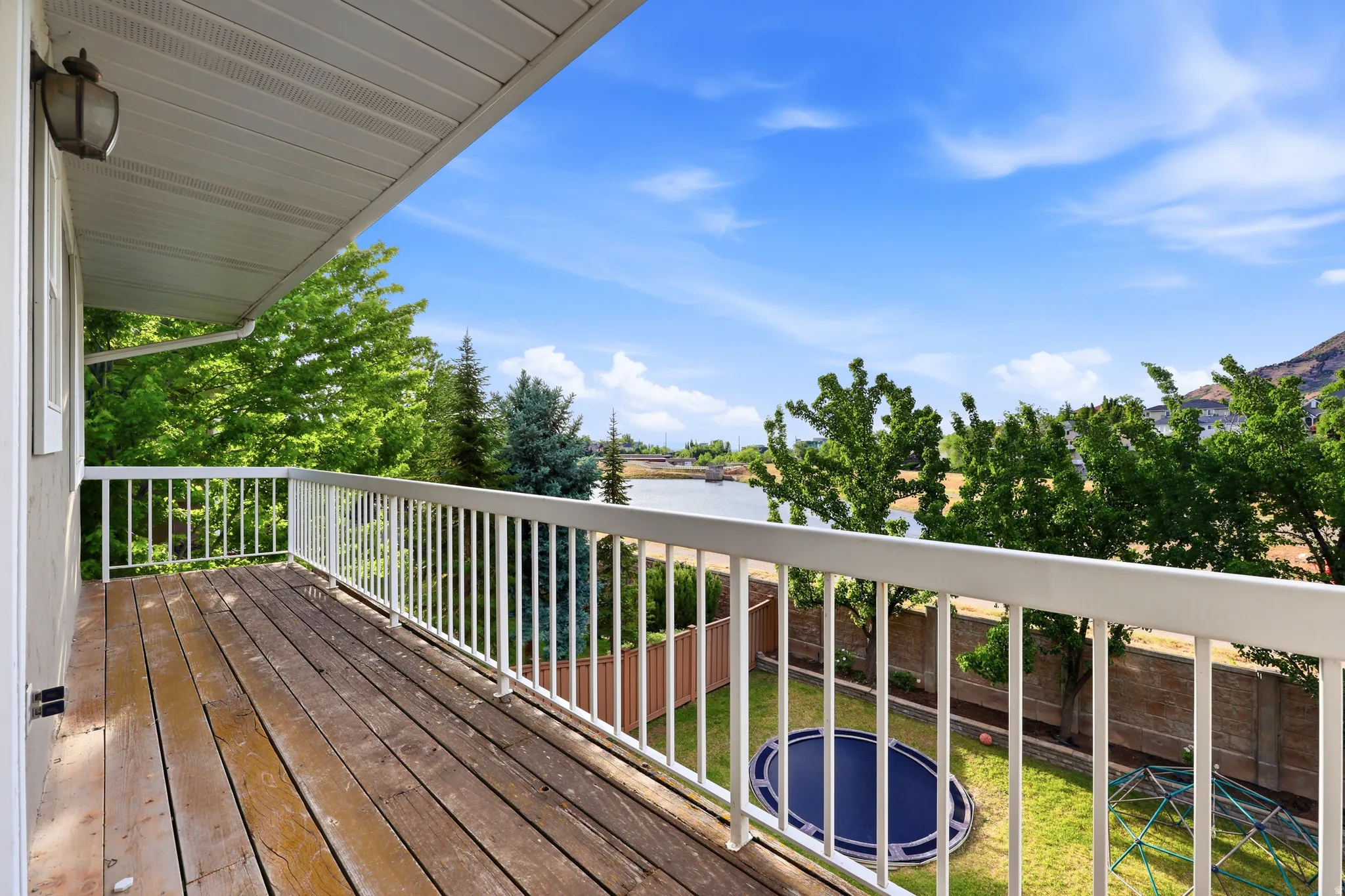 Outdoor balcony featuring wood-finish decking and white railings