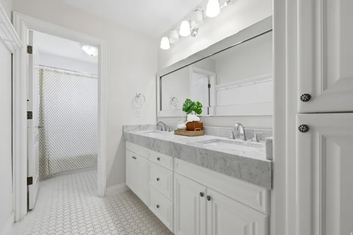 White shaker-style double vanity with a stone countertop and two undermount sinks