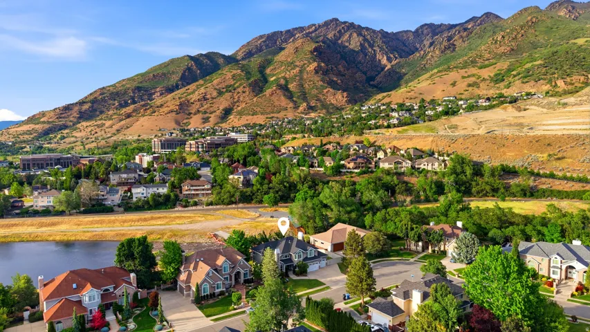 Aerial perspective showcasing a residential neighborhood with mountain backdrop and a body of water