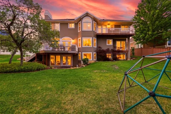 Expansive backyard featuring a manicured lawn and mature trees